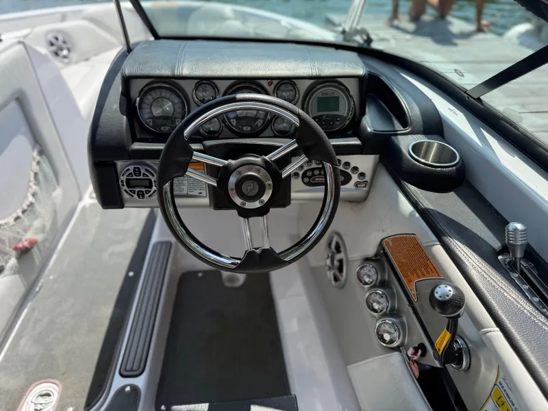Slide: The Image of 2008 Nautique Super Air 230 boat dashboard with steering wheel and control panel. - 12