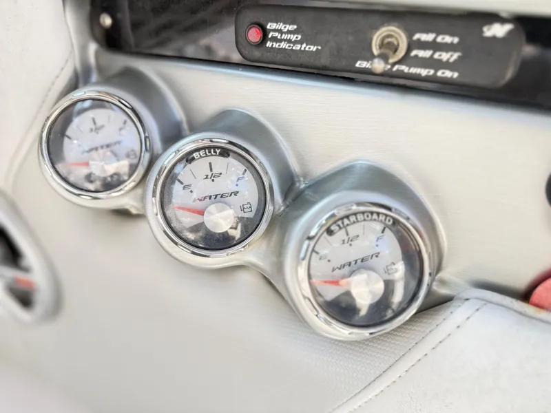 Slide: The Image of 2008 Nautique Super Air 230 dashboard with water level gauges and bilge pump indicator. - 13