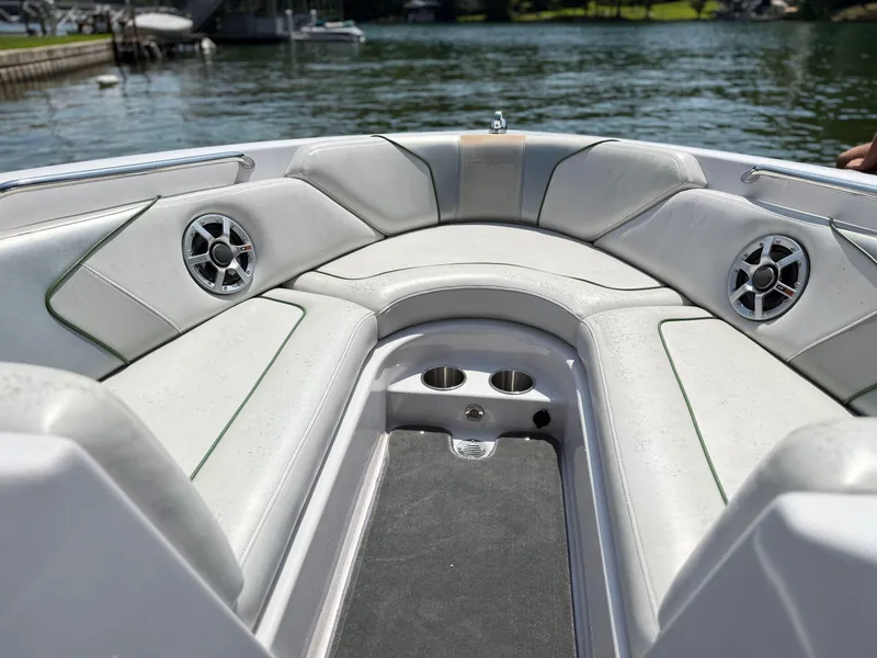 Slide: The Image of 2008 Nautique Super Air 230 boat interior with cushioned seating and speakers on a sunny day. - 16