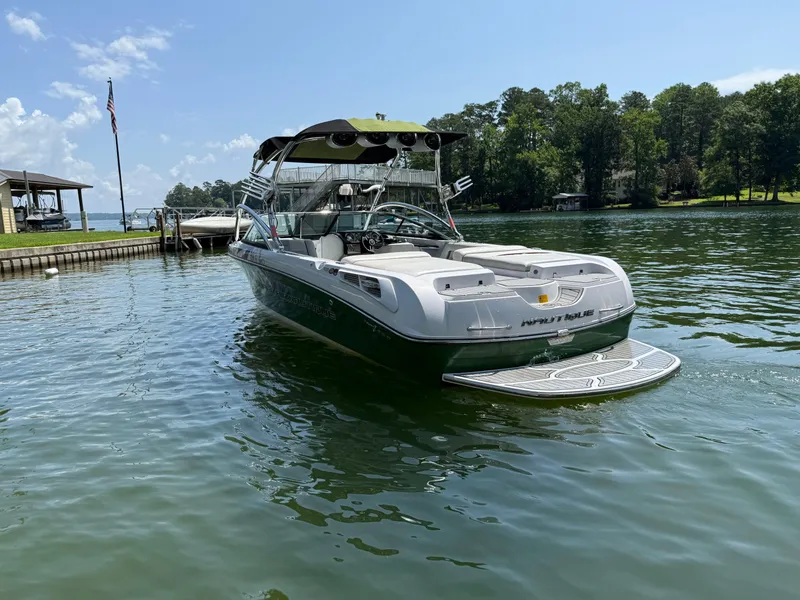 Slide: The Image of 2008 Nautique Super Air 230 boat docked on a sunny lake. - 2