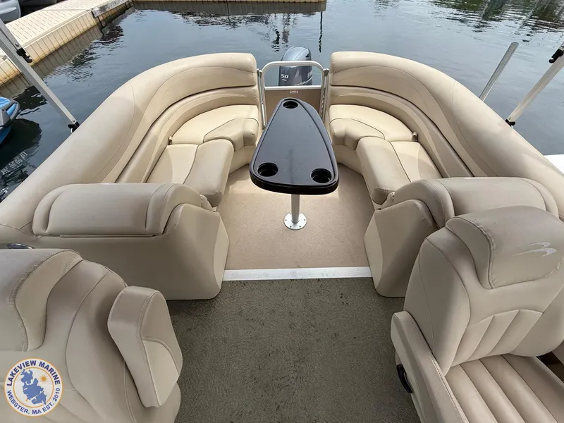 Slide: The Image of 2014 Bennington 2250 GSR pontoon boat interior with beige seating and central table. - 10