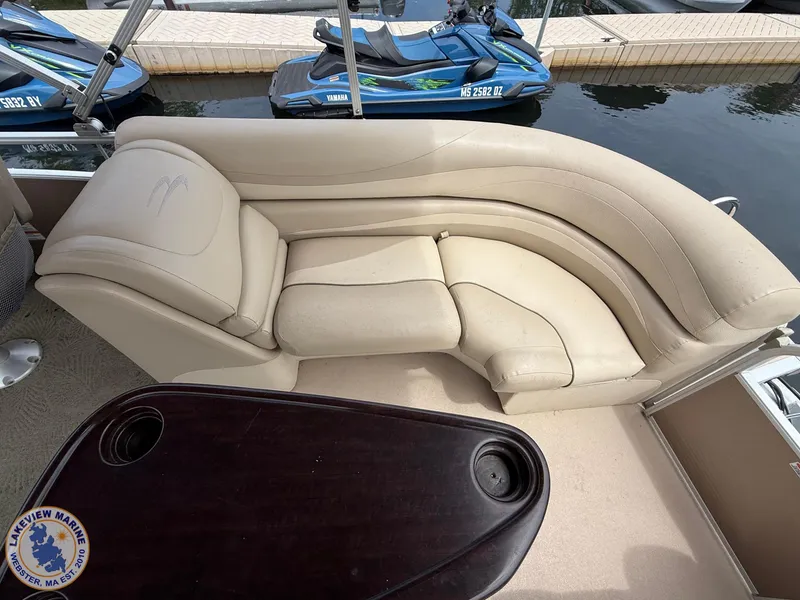 Slide: The Image of 2014 Bennington 2250 GSR boat interior with beige seating and dark wood table. - 11