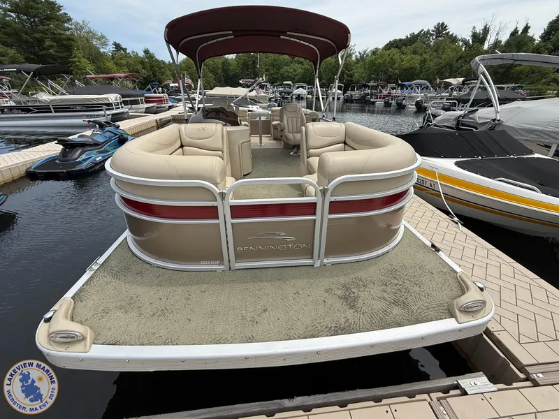 Slide: The Image of 2014 Bennington 2250 GSR pontoon boat docked at marina with canopy and seating. - 2