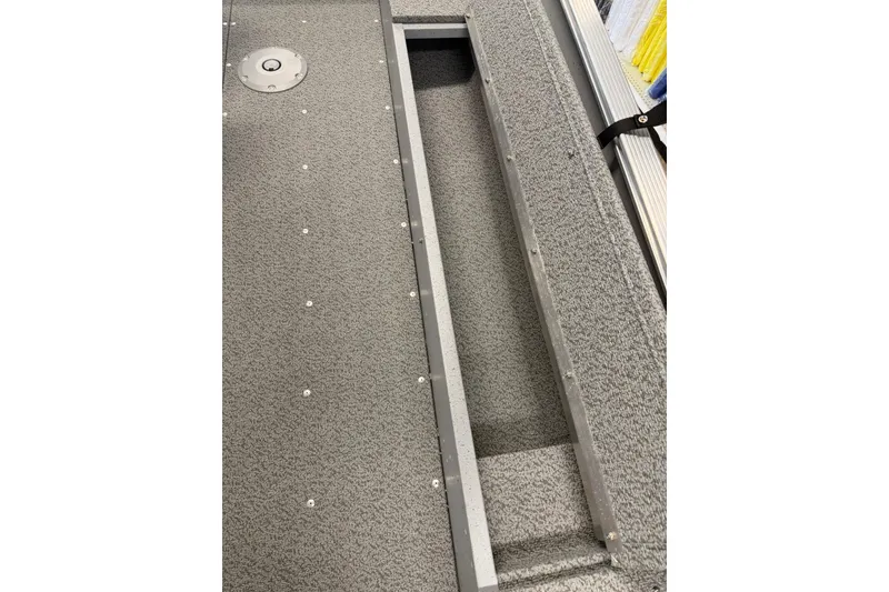 Slide: The Image of 2026 Lund 1600 Fury Tiller boat interior with storage compartment and textured flooring. - 10