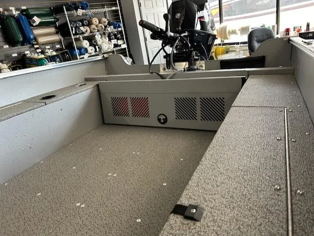 Slide: The Image of 2026 Lund 1600 Fury Tiller boat interior with steering controls and storage compartments. - 6