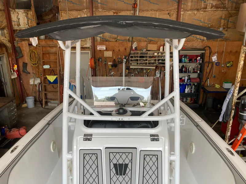 Slide: The Image of 2022 Wellcraft 202 Fisherman boat in a workshop, showcasing its console and T-top. - 21