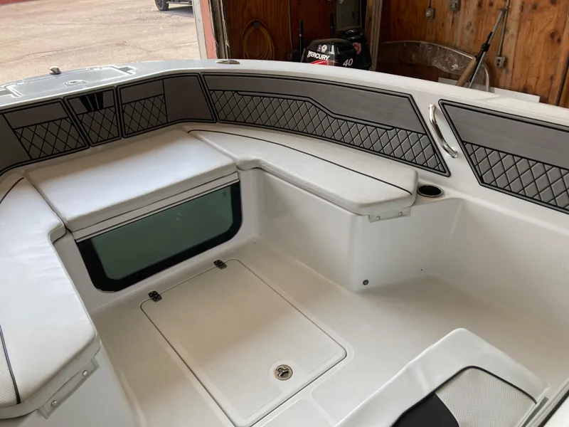 Slide: The Image of Interior of 2022 Wellcraft 202 Fisherman boat, featuring cushioned seating and storage compartments. - 23