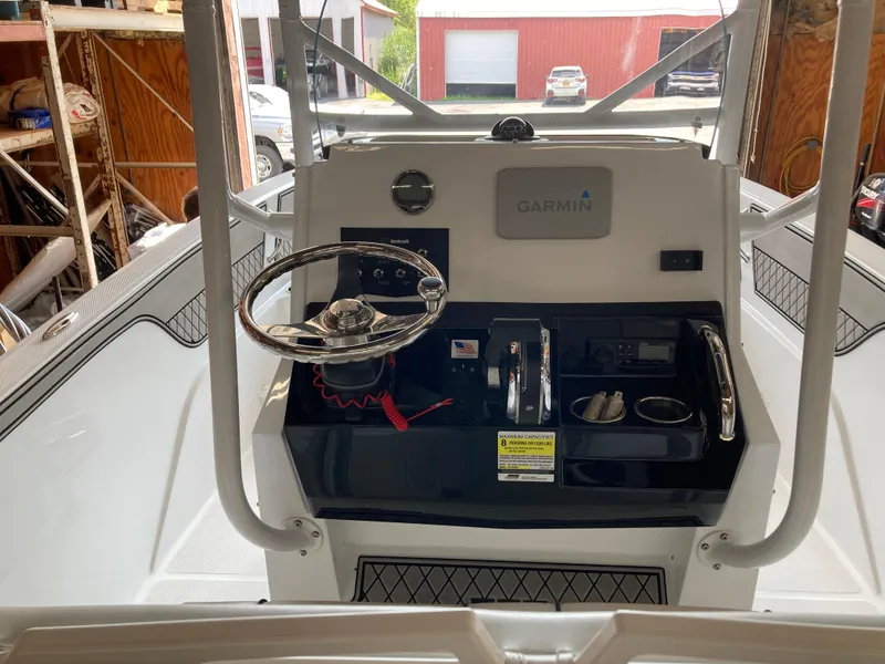 Slide: The Image of 2022 Wellcraft 202 Fisherman boat console with Garmin navigation system in a garage setting. - 31