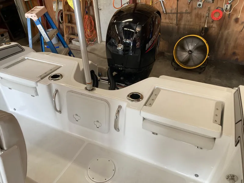 Slide: The Image of 2022 Wellcraft 202 Fisherman boat interior with Mercury engine in a workshop setting. - 33