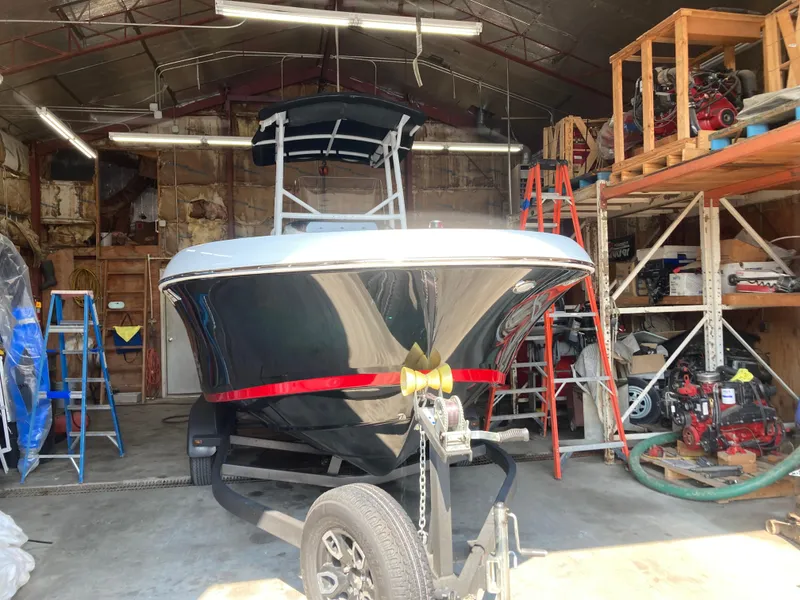 Slide: The Image of 2022 Wellcraft 202 Fisherman boat in a garage, surrounded by tools and equipment. - 41