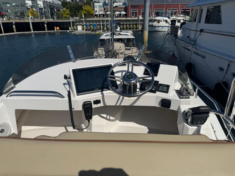 Slide: The Image of 2019 Ranger Tugs R-29 CB boat interior with cushioned seating and wooden deck. - 16