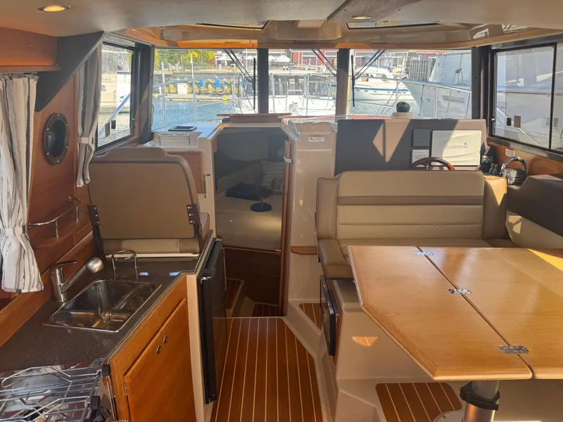Slide: The Image of 2019 Ranger Tugs R-29 CB docked at a marina, reflecting on calm water. - 5