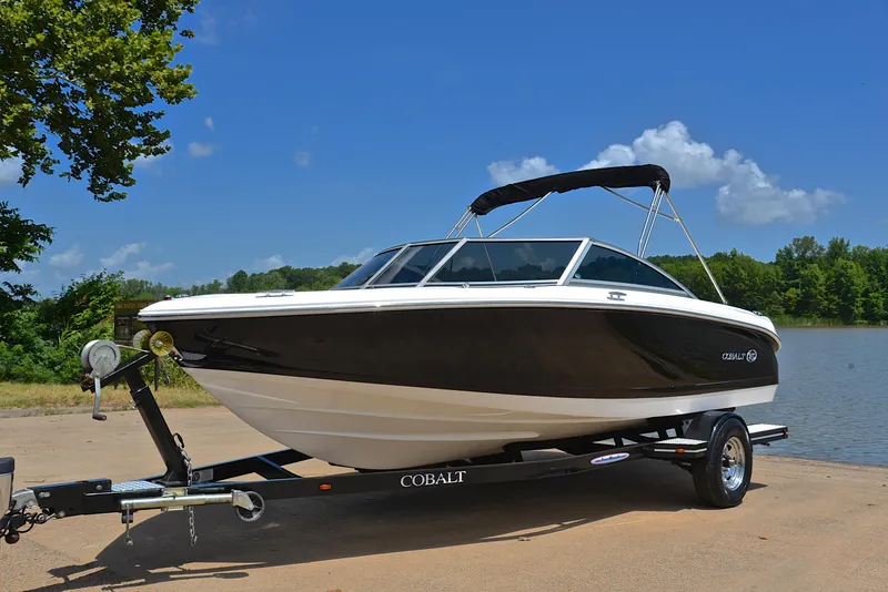 Slide: The Image of 2011 Cobalt 200 boat on trailer by a lake, under clear blue sky. - 10