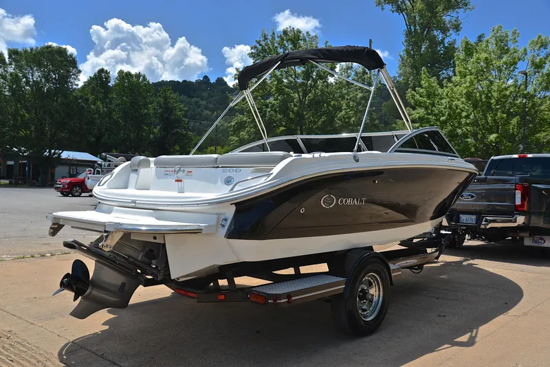 Slide: The Image of 2011 Cobalt 200 boat on trailer, parked outdoors under a clear sky. - 14