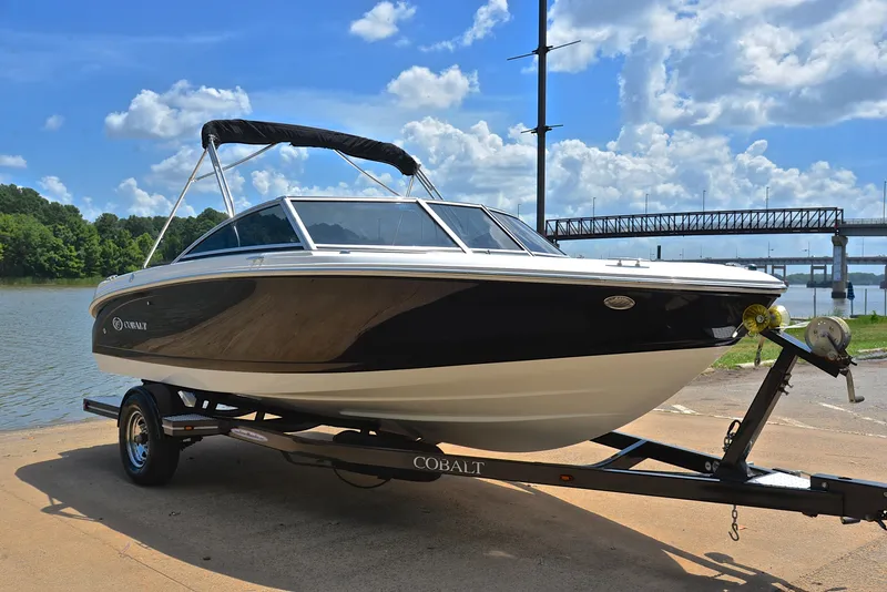 Slide: The Image of 2011 Cobalt 200 boat on trailer by a lake under a blue sky. - 16