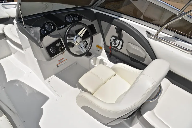 Slide: The Image of 2011 Cobalt 200 boat interior with steering wheel and white captain's chair. - 24