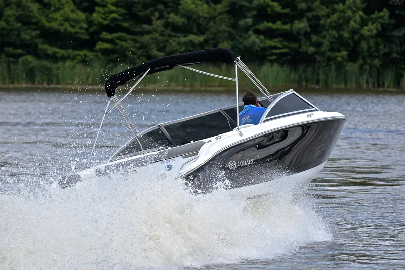 Slide: The Image of 2011 Cobalt 200 boat speeding on a lake with lush green background. - 5