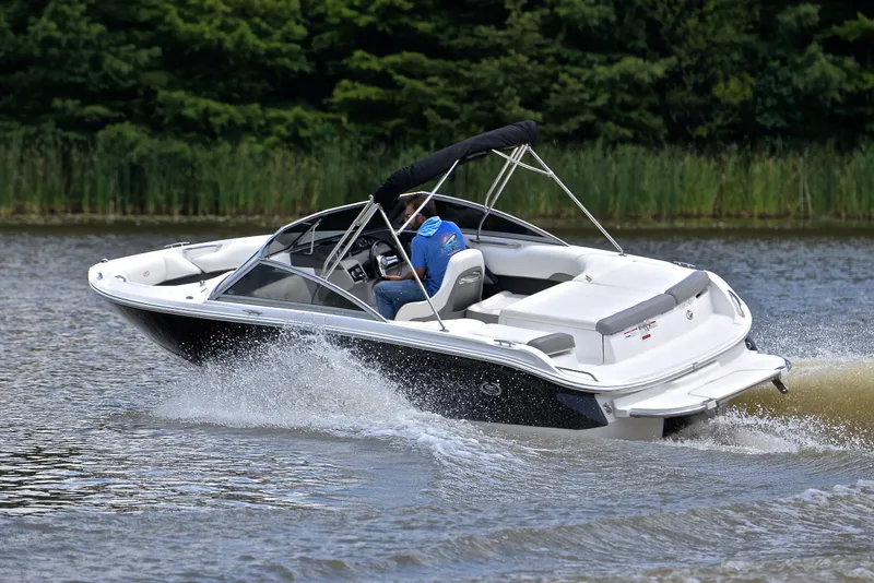 Slide: The Image of 2011 Cobalt 200 boat cruising on a lake with lush green background. - 6