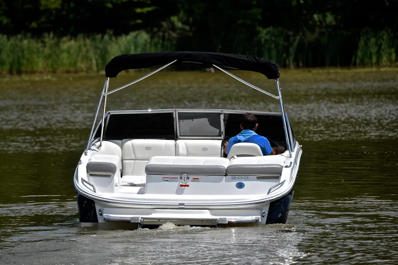 Slide: The Image of 2011 Cobalt 200 boat cruising on a calm lake with lush greenery. - 8