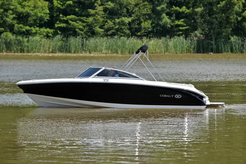Slide: The Image of 2011 Cobalt 200 boat on a calm lake with lush green background. - 9