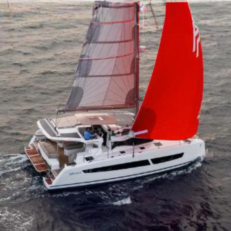 The Image of 2025 Fountaine Pajot NEW 41 catamaran sailing at sunset with vibrant red sails. - 0