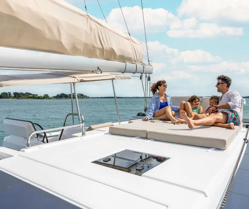 Slide: The Image of Family relaxing on 2025 Fountaine Pajot NEW 41 catamaran deck, enjoying sunny day at sea. - 22