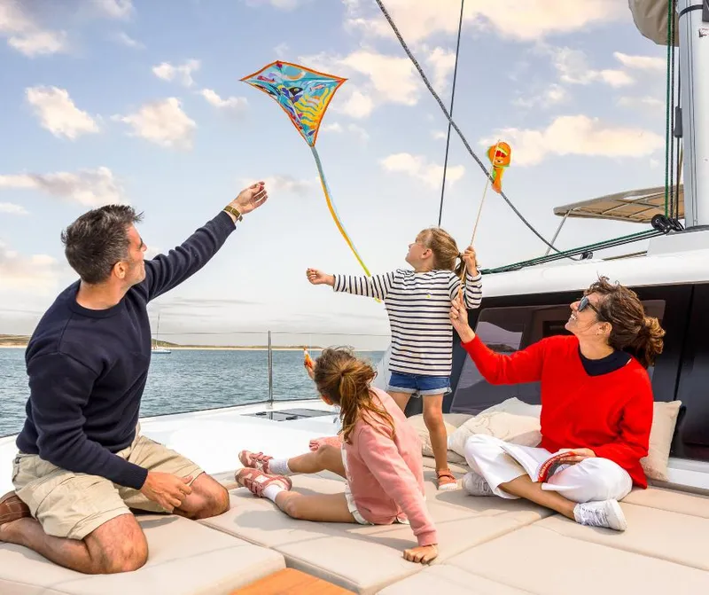 Slide: The Image of Family flying kite on Fountaine Pajot NEW 41 catamaran, 2025 model, enjoying sunny day at sea. - 35