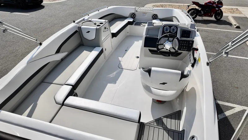 Slide: The Image of 2026 Starcraft SVX 191 OB boat interior with modern dashboard and seating in a parking lot. - 2