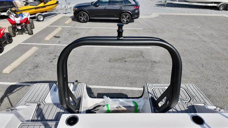 Slide: The Image of 2026 Starcraft SVX 191 OB boat interior with black railing, parked vehicles in background. - 3