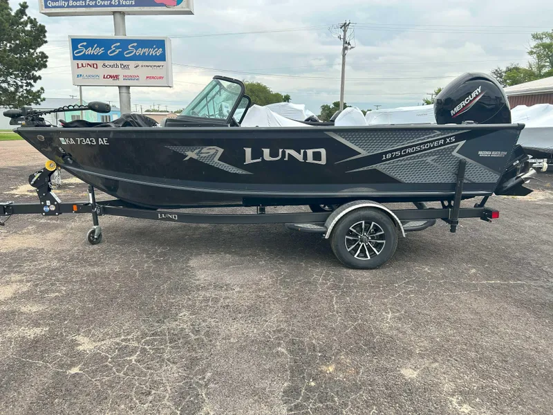 Slide: The Image of 2024 Lund 1875 Crossover XS boat on trailer, displayed outdoors. - 3