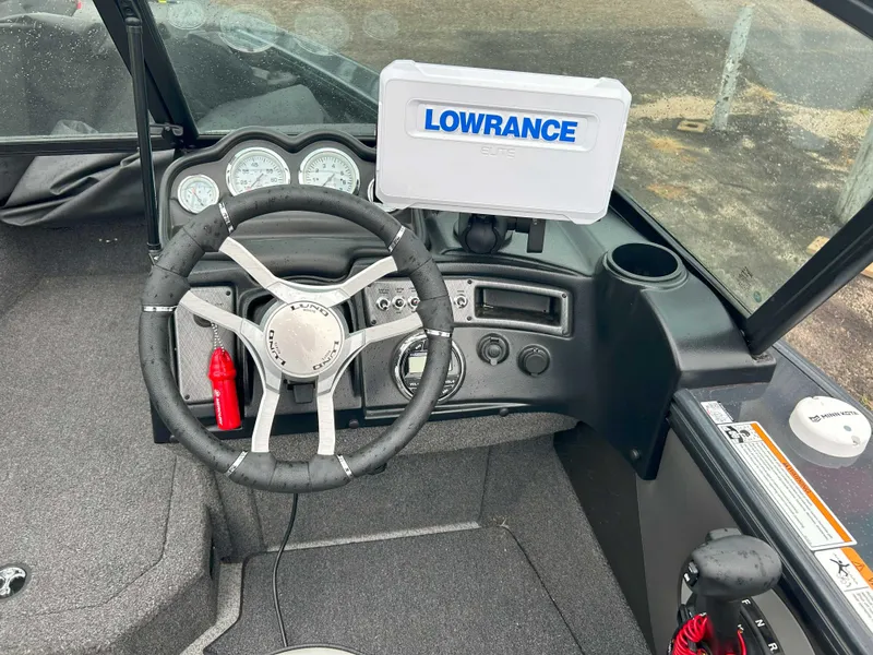 Slide: The Image of 2024 Lund 1875 Crossover XS boat dashboard with Lowrance Elite display and steering wheel. - 5