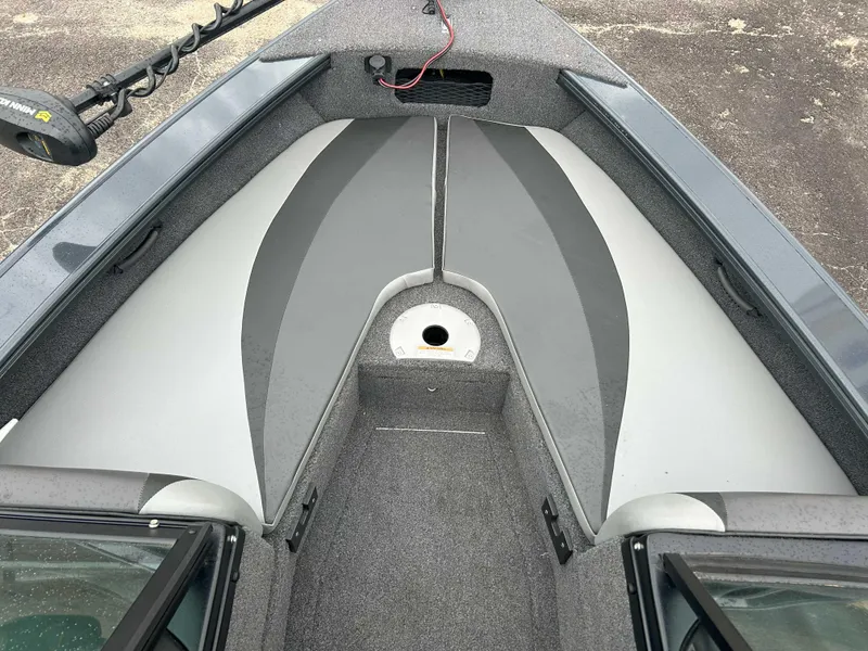 Slide: The Image of 2024 Lund 1875 Crossover XS boat interior with gray seating and carpeted flooring. - 7