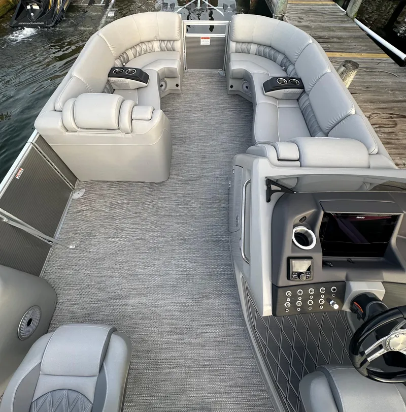 Slide: The Image of 2024 Bennington R 23 Swingback pontoon boat interior with plush seating and modern dashboard. - 10
