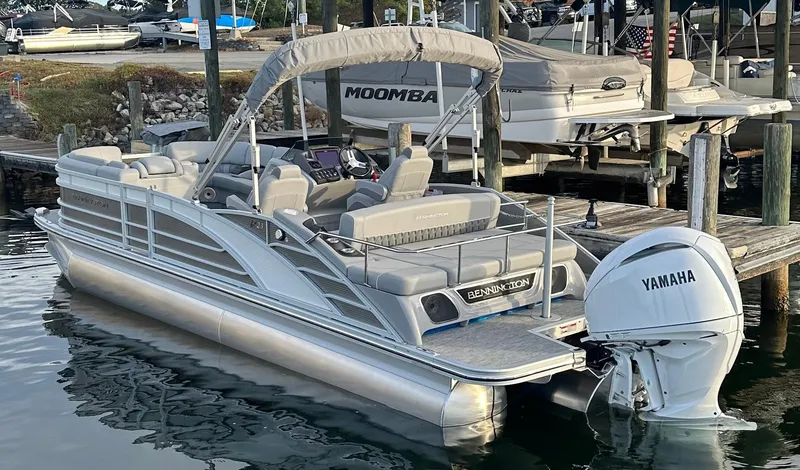 Slide: The Image of 2024 Bennington R 23 Swingback pontoon boat docked with Yamaha outboard motor. - 5