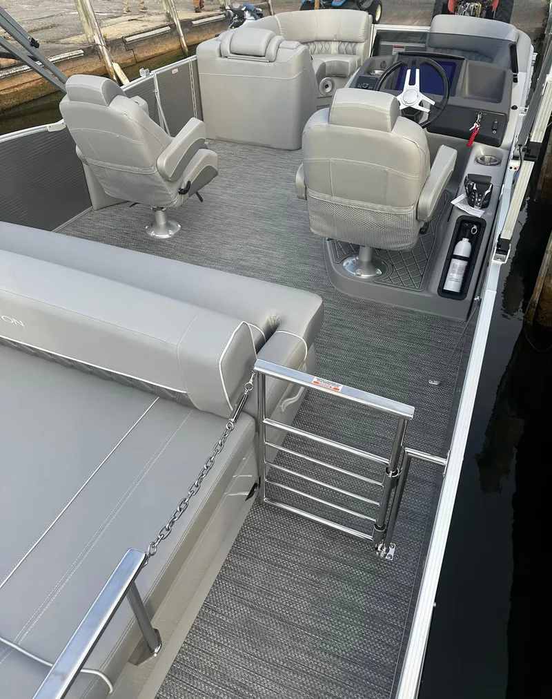 Slide: The Image of 2024 Bennington R 23 Swingback pontoon boat interior with gray seating and helm. - 8