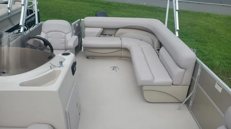 Slide: The Image of 2014 Starcraft SD 190 boat interior with beige seating and steering console. - 4