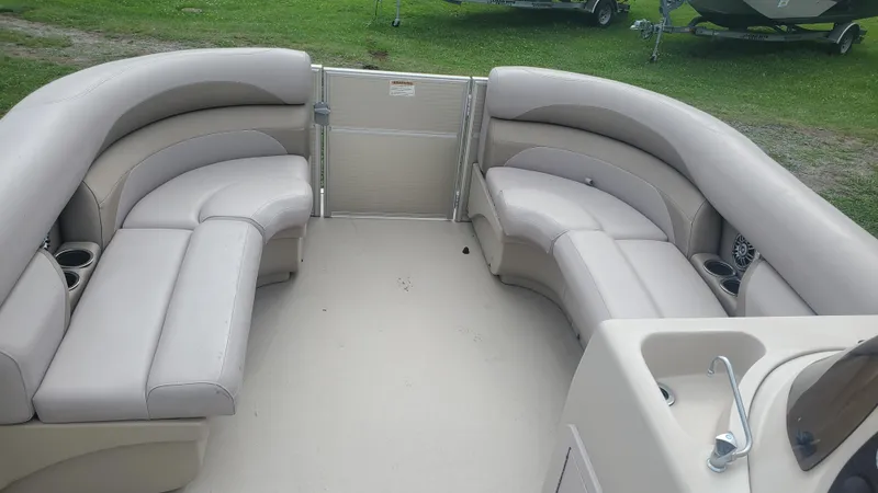 Slide: The Image of 2014 Starcraft SD 190 boat interior with beige seating and cup holders. - 6