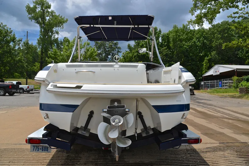 Slide: The Image of Rear view of a 2000 Cobalt 246 boat on a trailer, surrounded by trees. - 14