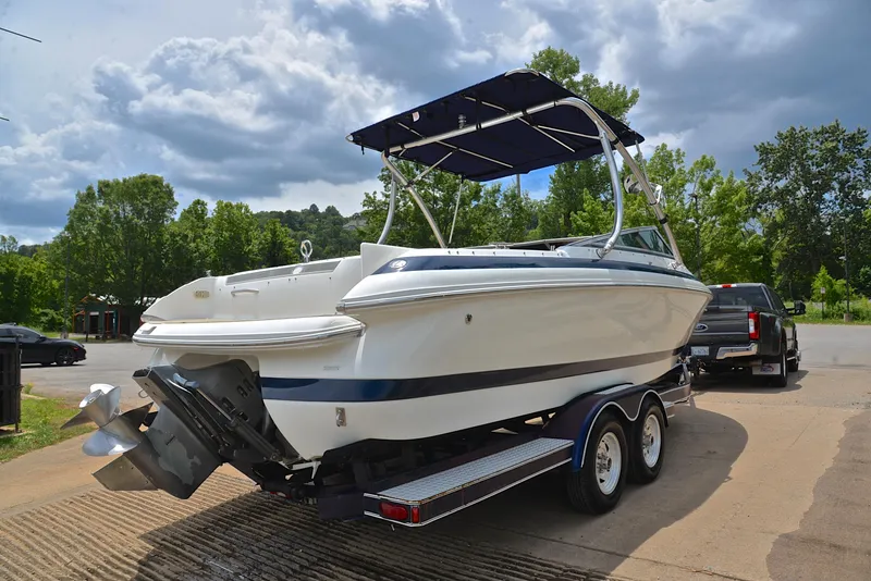 Slide: The Image of 2000 Cobalt 246 boat on trailer, parked outdoors under cloudy sky. - 15