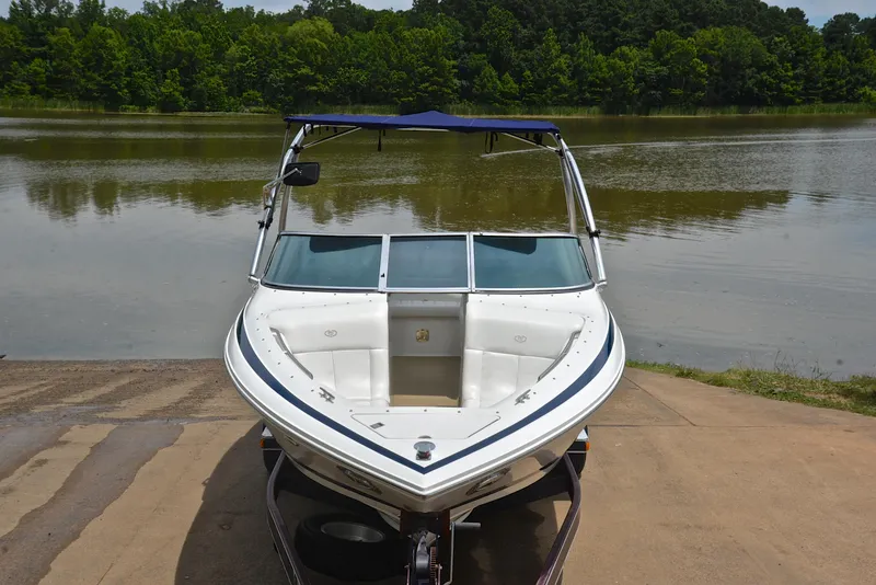 Slide: The Image of Cobalt 246 boat from 2000 on a trailer by a lake. - 18