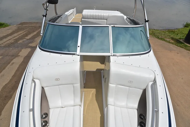 Slide: The Image of 2000 Cobalt 246 boat with white interior and windshield, docked by the water. - 21