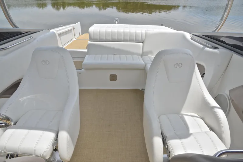 Slide: The Image of Interior of a 2000 Cobalt 246 boat with white seating and water view. - 23