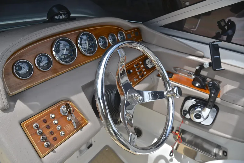 Slide: The Image of Steering wheel and dashboard of a 2000 Cobalt 246 boat, featuring wood accents and gauges. - 28