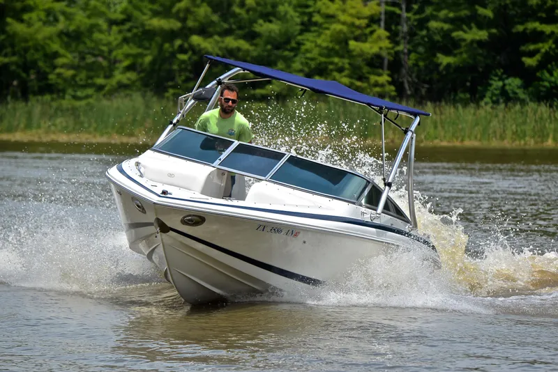 Slide: The Image of A 2000 Cobalt 246 boat navigating through water with a person steering. - 6
