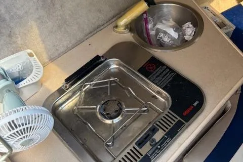 Slide: The Image of 1995 Wellcraft 23 Excel boat kitchenette with stove, sink, and fan. - 13