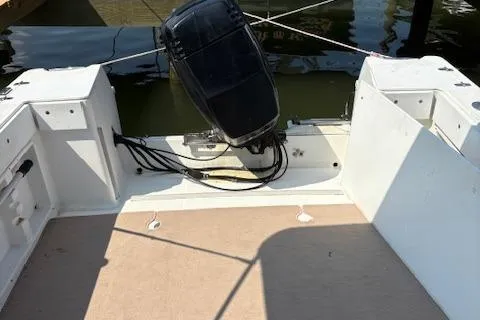 Slide: The Image of 1995 Wellcraft 23 Excel boat stern with outboard motor, docked on calm water. - 15