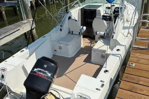 Slide: The Image of 1995 Wellcraft 23 Excel boat docked, featuring spacious seating and a Mercury outboard motor. - 17