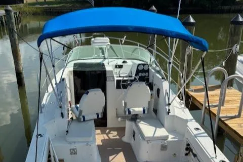 Slide: The Image of 1995 Wellcraft 23 Excel boat with blue canopy, docked at a marina. - 3