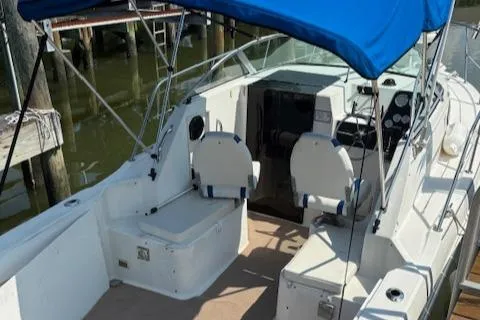 Slide: The Image of 1995 Wellcraft 23 Excel boat with blue canopy, docked in a marina. - 4