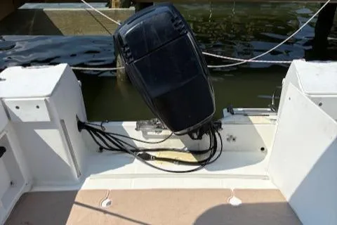 Slide: The Image of 1995 Wellcraft 23 Excel boat with outboard motor, docked by the water. - 9